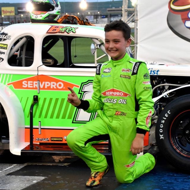 Brexton Busch kneeling for a picture after his first career Legend Car victory.