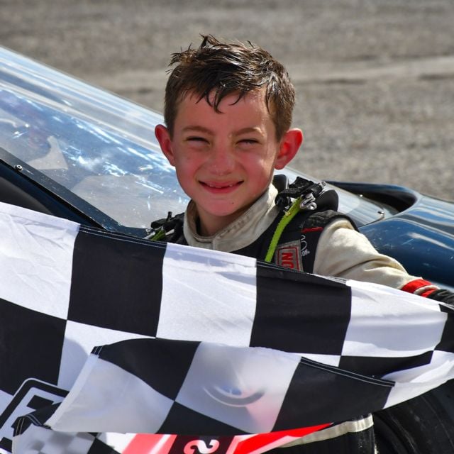 Casen Tate holds the checkered flag after winning Thursday's Bandits Feature.