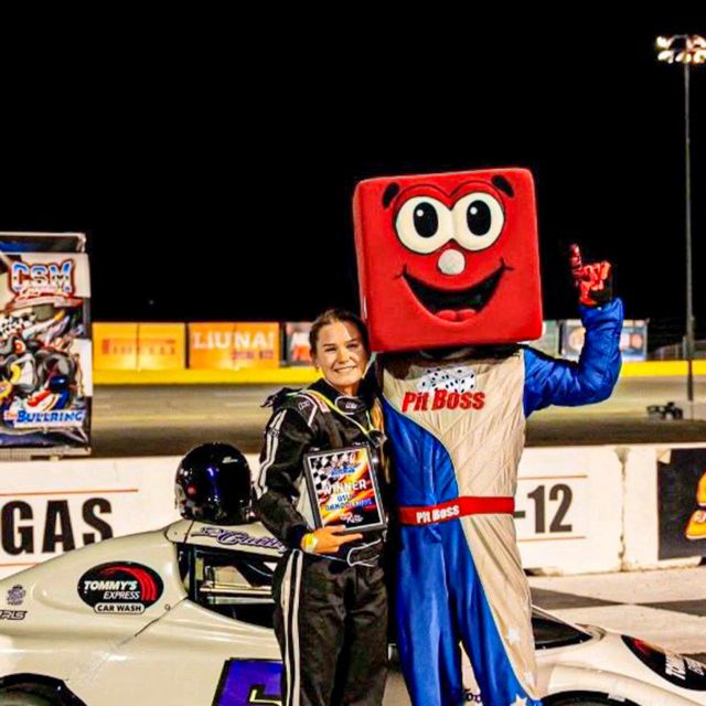 Caitlyn Ford poses with Pit Boss after winning in her Bandolero at The Bullring at Las Vegas Motor Speedway.