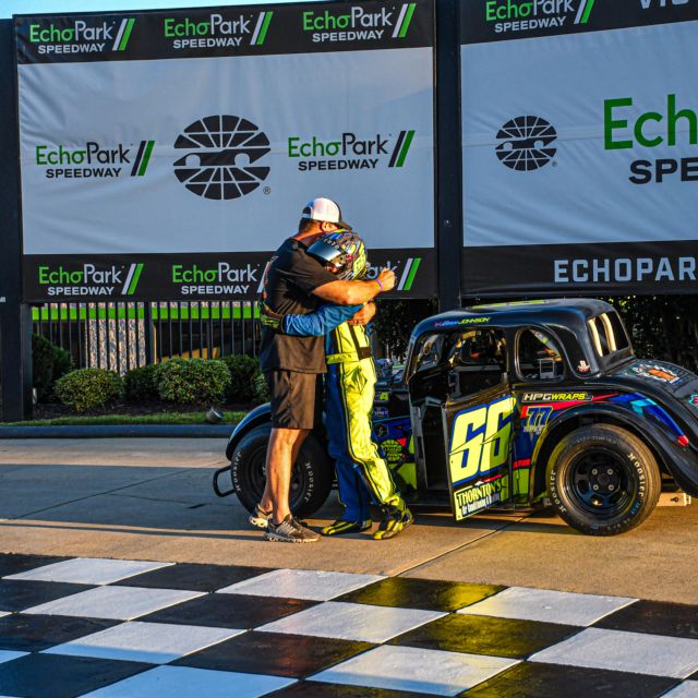 Evan Johnson hugs his father after winning the Chargers Division racing experience feature Wednesday night. 