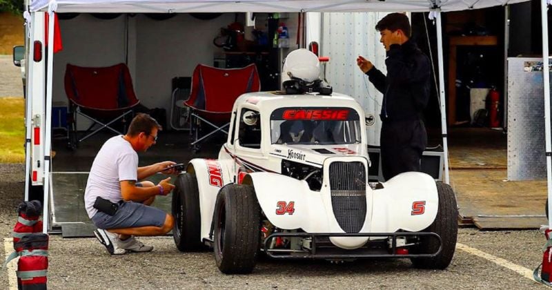 Kyle Caissie prepares to drive as his father puts finals touches on his Legend Car. 